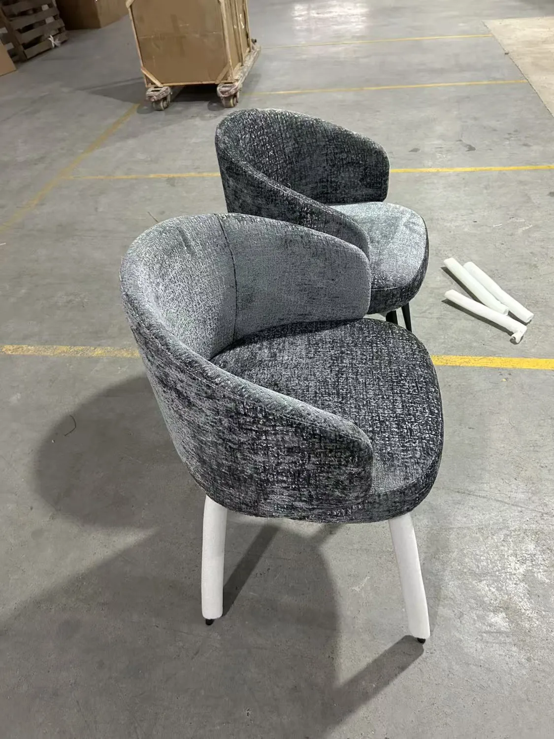 Grey upholstered dining chair samples viewed at an angle in the workshop