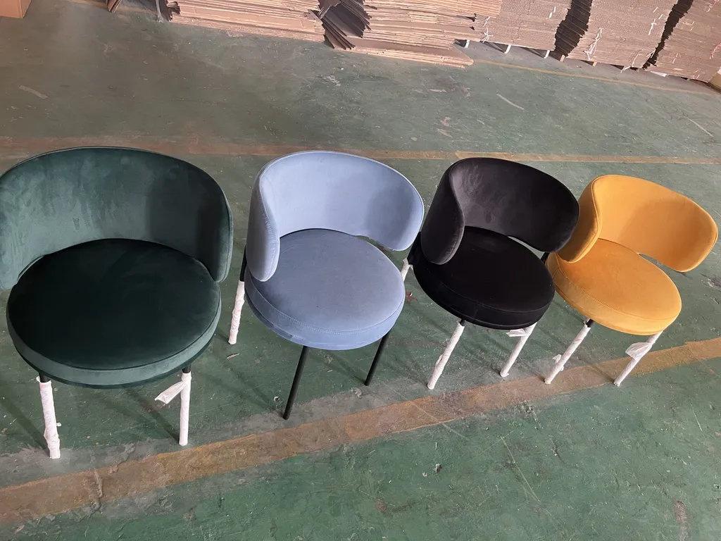 Four 22205 chairs in green, light blue, black and yellow velvet in the workshop
